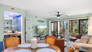 A spacious living area with a dining table, comfortable seating, a television, and a view of the outdoors.