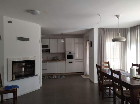 Una cocina moderna con gabinetes blancos, horno empotrado y microondas.