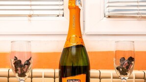 En flaske Cinzano Prosecco DOC på et bord med to glas fyldt med chokoladepastiller.