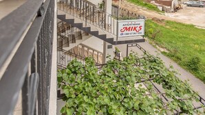 A multi-story building with a balcony, a staircase, and a sign advertising 'APARTMANTI MIKE5'. - Perfect Budva Stay Near the Sea & Aqua Park - Studio with Terrace 1/2 (Budva)