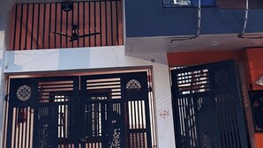 A multi-story building with a prominent sign advertising a real estate service. - Shreeram guest house (Ujjain)