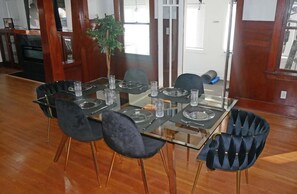 Enjoy meals with friends and family at this dining area, featuring a glass-top table and six comfortable chairs.