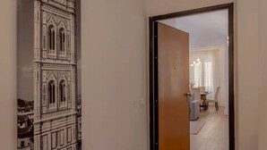A hallway with a door leading to a dining area.