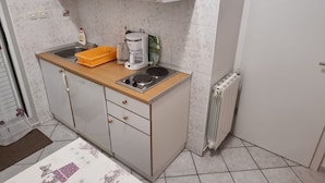 A compact kitchen with a sink, a coffee maker, and a radiator. - Apartments Pansion Franka 3* - Apartment 10 (Brist)