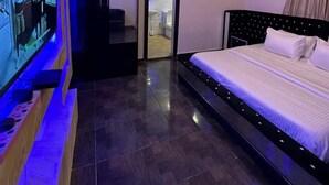 A modern bedroom with a large bed, a TV mounted on the wall, and a ceiling light fixture. - Spacious 3-bedroom apartment in excellent Abuja with AC, WiFi, fitness room (Abuja)