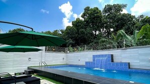 A swimming pool with a tiled edge, surrounded by artificial grass and a stone border. - Spacious 3-bedroom apartment in excellent Abuja with AC, WiFi, fitness room (Abuja)