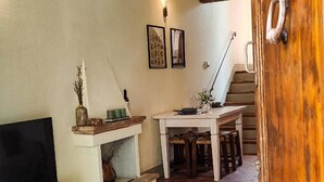 A cozy living room with a fireplace, a television, and a dining area with a table and chairs. - Tuscan Escape with pool and vineyard view - Gaiole in Chianti (Gaiole in Chianti)