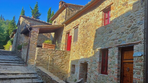 A stone building with a wooden door and red shutters, featuring a stone staircase leading up to the entrance. - Tuscan Escape with pool and vineyard view - Gaiole in Chianti (Gaiole in Chianti)