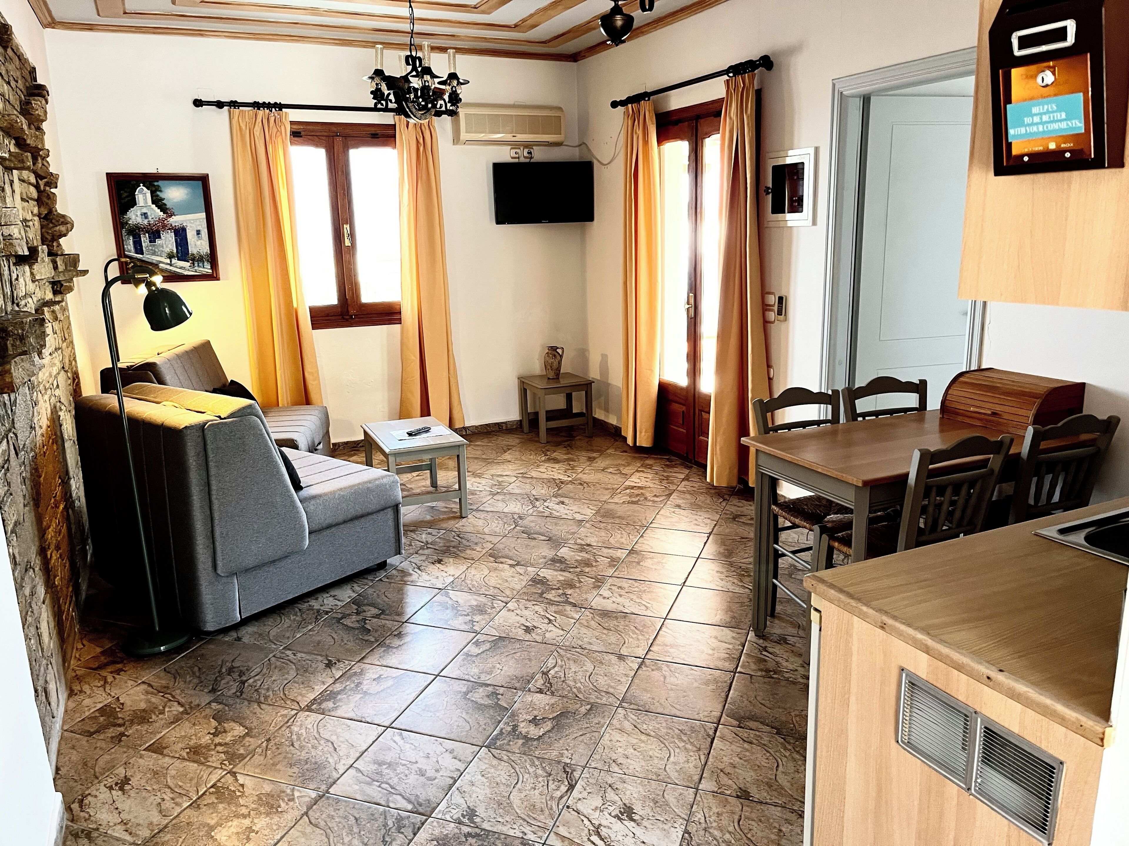 Una sala de estar acogedora con un sofá, una mesita y un comedor con sillas y una mesa de madera.