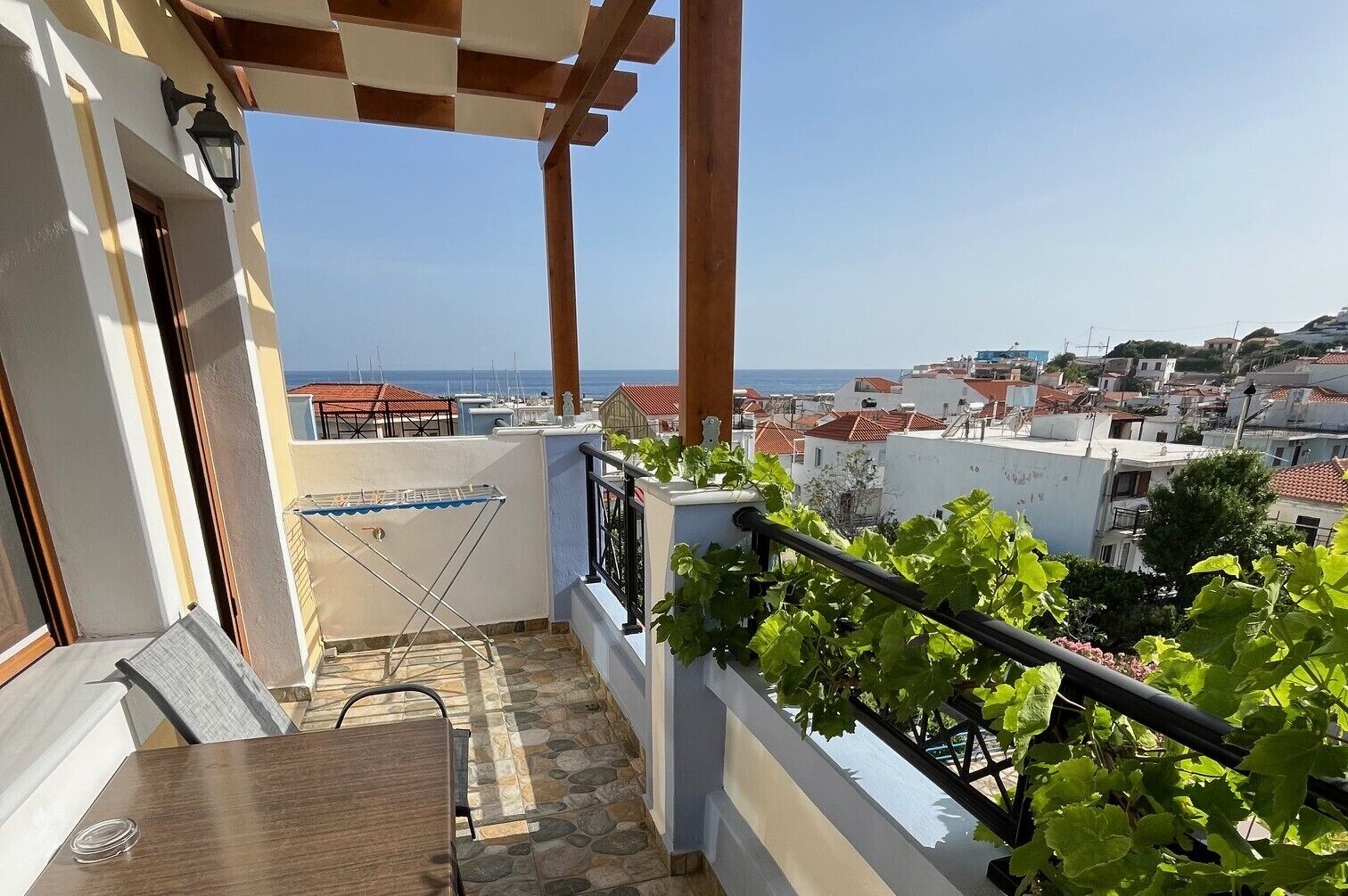Un balcón con vista al mar, un tendedero y una mesa.