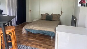 A bedroom with a bed, a desk, a chair, and a small table. - Studio in a country home (Cordemais)