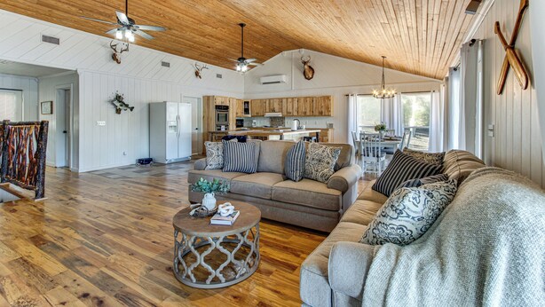 A spacious living area with a high ceiling, wooden floors, and a cozy seating arrangement. - Tranquil Gantt Lake Home w/ Deck & Patio! (Andalusia)
