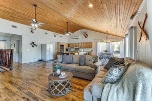A spacious living area with a high ceiling, wooden floors, and a cozy seating arrangement. - Tranquil Gantt Lake Home w/ Deck & Patio! (Andalusia)