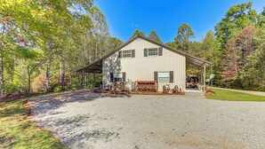 A single-story building with a gravel driveway, surrounded by trees and a clear sky. - 8 Mi to Tellico Plains: Family Home Near Trails! (Englewood)