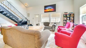 A spacious living room with a staircase, a large painting, a bookshelf, and a red armchair. - 8 Mi to Tellico Plains: Family Home Near Trails! (Englewood)