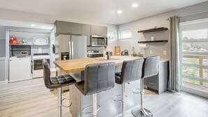 A modern kitchen with a central island, bar stools, and built-in appliances. - Pasture & Pond Views: Lovely Lutz Apartment (Lutz)