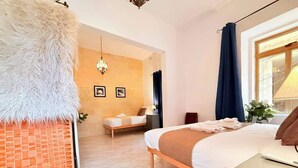 Ein Hotelzimmer mit einem Bett, einem Schreibtisch, einem Stuhl, einer Lampe und einem Fenster mit Vorhängen.