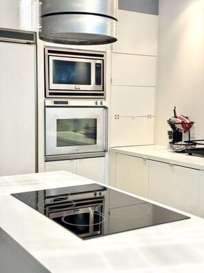 A modern kitchen with a built-in oven, microwave, and a stovetop. - Old City 2BR Apt w/ Shuffleboard! Walk Everywhere! (Philadelphia)
