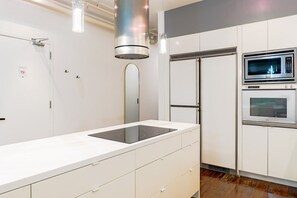 Una cocina moderna con estufa, microondas y horno integrados.