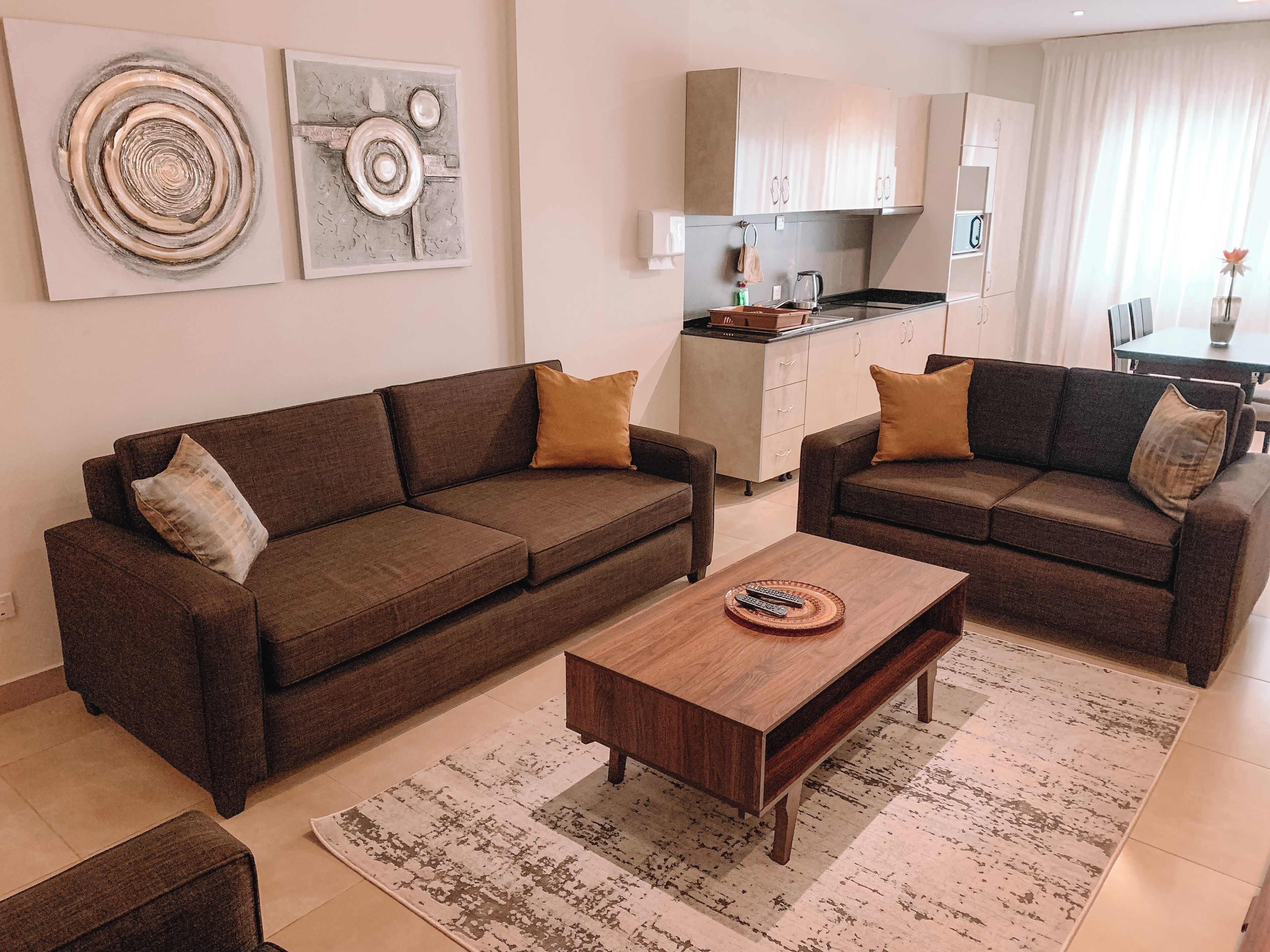 A living room with two brown sofas, a wooden coffee table, and a patterned rug.