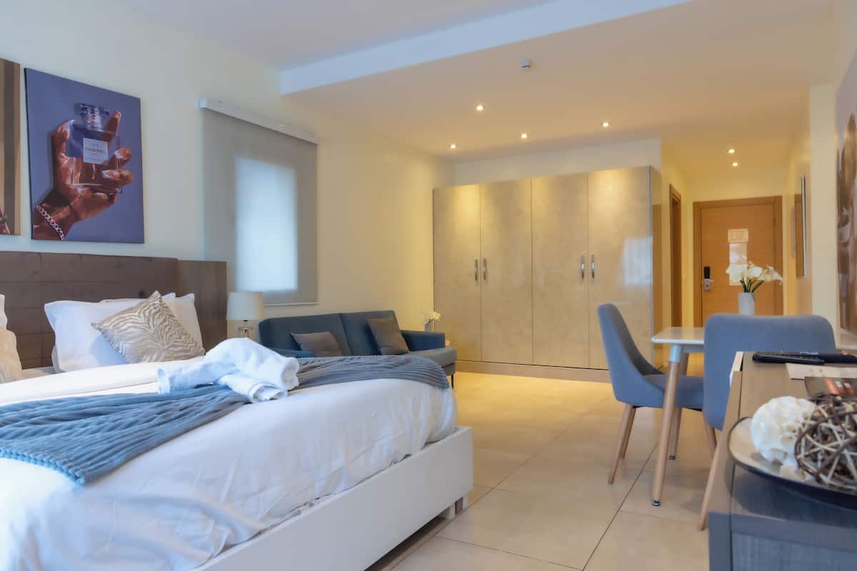 Une chambre d’hôtel moderne avec un grand lit, un bureau et une armoire.