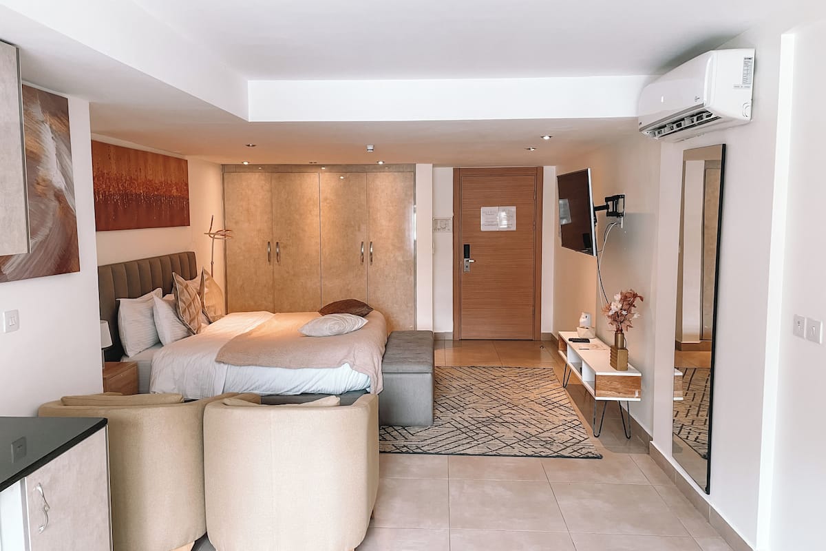 Une chambre moderne avec un lit, un canapé, un bureau et une armoire.