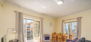 Enjoy meals in this spacious living area with a city view, dining table, and mounted TV.