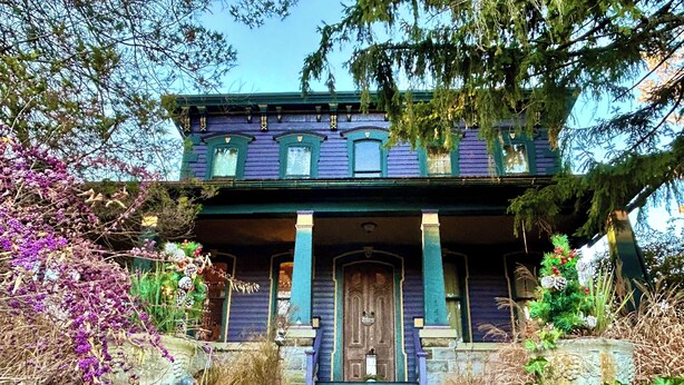 A two-story house with a porch, stone steps, and a wooden door. - Ruby Room -The Amethyst Inn Bed & Breakfast- jacuzzi tub, fireplace, breakfast (Adamstown)