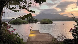 A stone pathway leading to a body of water with a view of a mountain in the background.