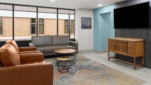 A modern living room with a sofa, a coffee table, a TV, and a cabinet. - Super 8 By Wyndham Great Falls City Center (Great Falls)