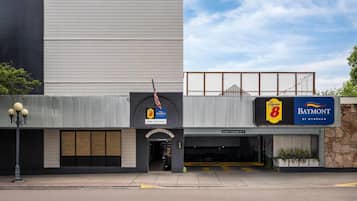 A building with a lobby entrance, a garage clearance sign, and a sign for a restaurant named Baymont.