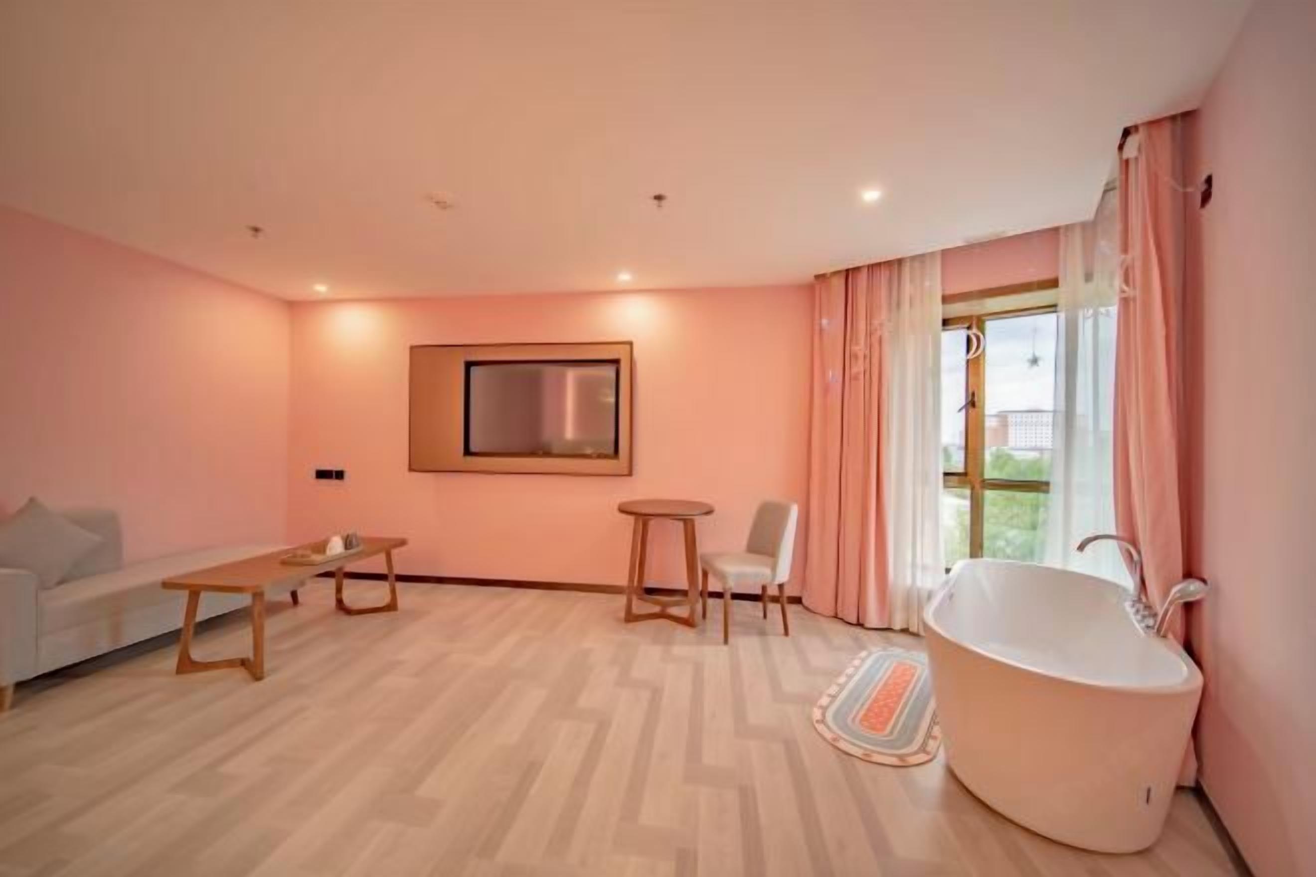 Una sala de estar moderna con un sofá, una mesa de centro, una mesita redonda y una bañera grande.
