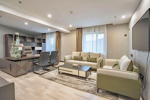 Un salon moderne avec un canapé, une table basse et un téléviseur.