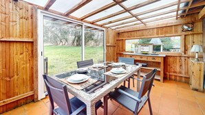Un comedor de madera con un portón de cristal que da a un jardín.