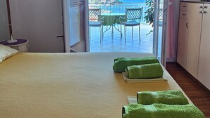 Una stanza con un letto, una scrivania e vista sul mare.