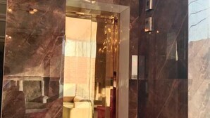 A modern elevator with a glass door, surrounded by marble walls. - Abhivadya Gange  (Varanasi)