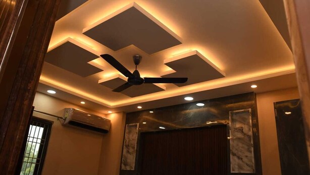 A ceiling with recessed lighting and a ceiling fan. - Abhivadya Gange  (Varanasi)