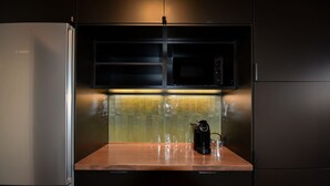 Una cocina con un refrigerador Bosch, un microondas y una cafetera sobre la encimera.