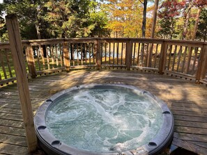 A hot tub on a wooden deck with a wooden railing, surrounded by trees. - del Sol - Private Hottub overlooking the 1000 Islands (Lansdowne)