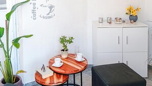 A small, cozy room with a wooden table and two chairs, a potted plant, a white cabinet, and a black ottoman. - 2 bedroom awesome apartment in Vir (Vir)