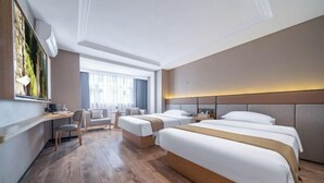 Habitación de hotel con una cama grande, un escritorio, una silla y una ventana con cortinas.