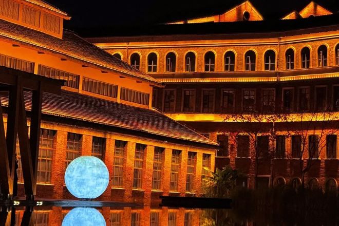 A large building with multiple arches and a reflective pool.