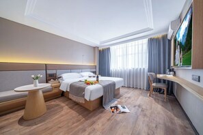 Una habitación de hotel moderna con cama, mesita de noche, zona de estar y escritorio.