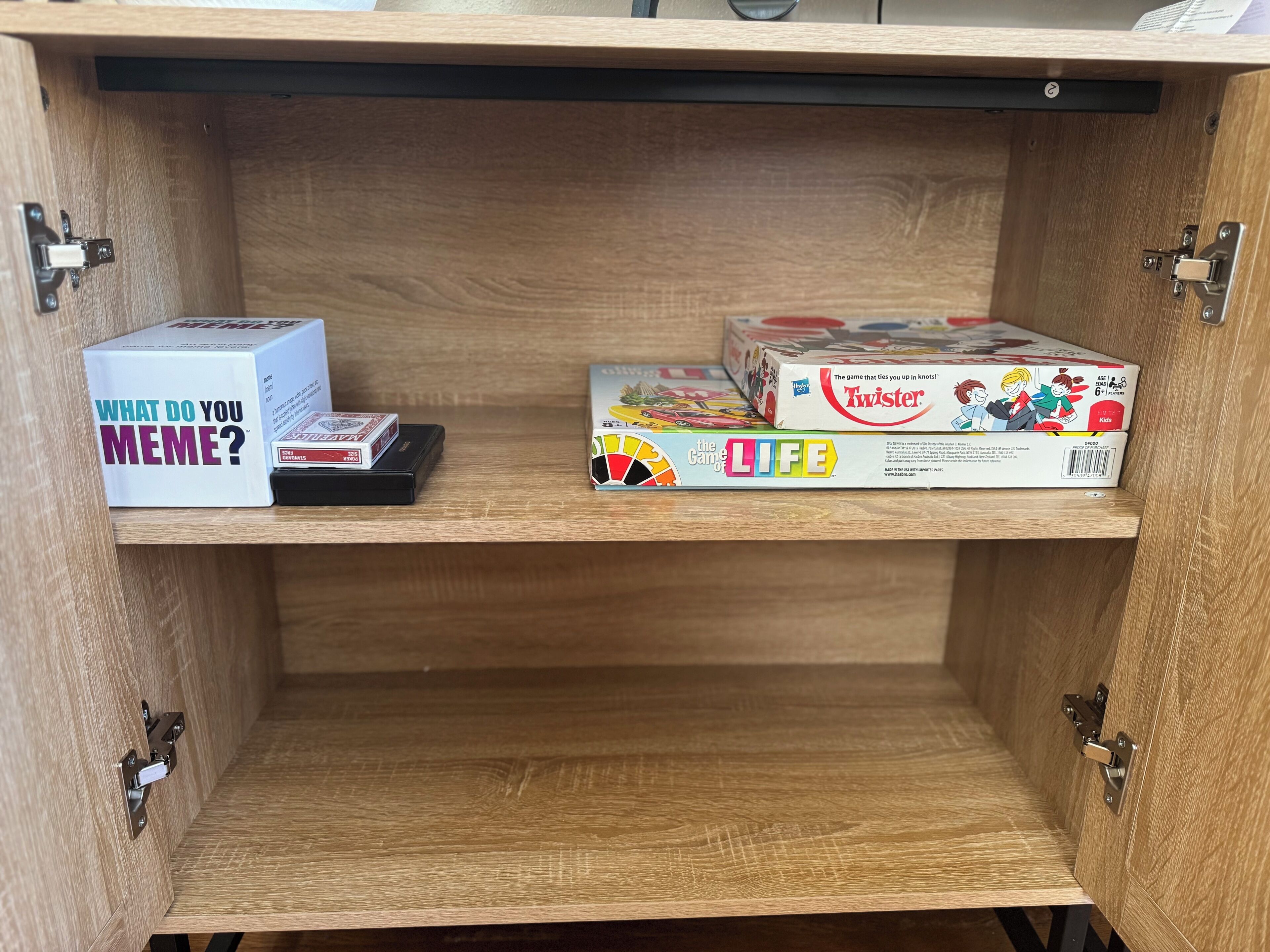 Un mueble de madera con dos repisas, cada una sosteniendo una caja de juego.
