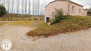 Una casa de dos pisos con entrada de grava y jardín.