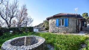 A stone building with blue shutters, a stone well, and a clear sky. - 4 bedroom lovely home in Ricadi (Ricadi)