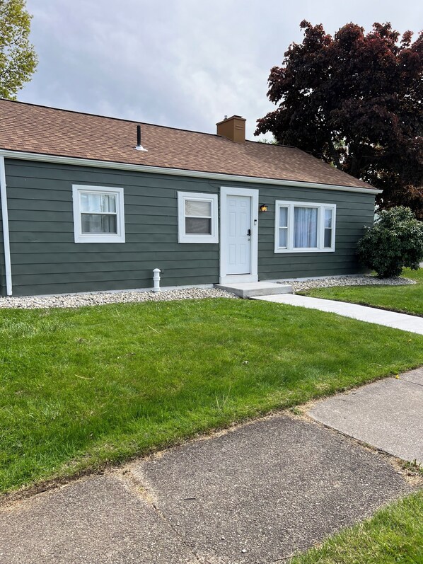 A single-story house with a front door, two windows, and a small porch. - Beautiful 3-bedroom house in wonderful Erie with AC, WiFi, large driveway (Erie)