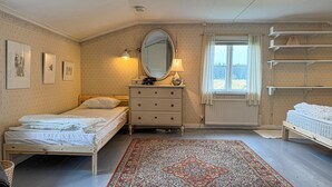 A bedroom with two beds, a dresser, a mirror, a lamp, and a window with a view of the outdoors. - 4 bedroom amazing home in Skillingaryd (Skillingaryd)
