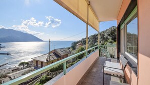 A balcony with a view of a lake and mountains, a tiled floor, and a railing. - Amazing apartment in Recco with WiFi (Recco)