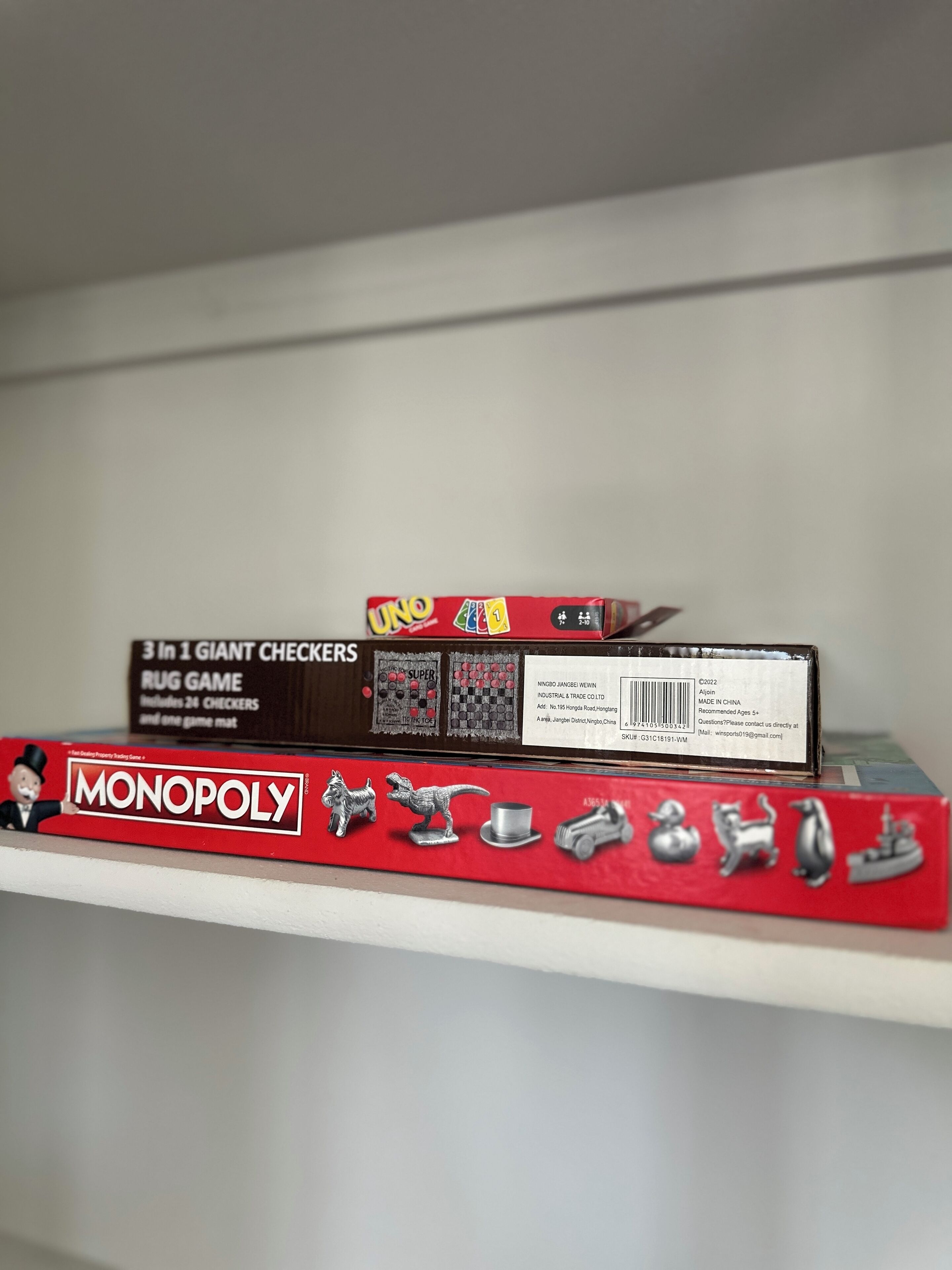 A shelf with two game boxes: UNO and Monopoly.